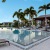 Large pool with palm trees overlooking the lake at Ridgelake Apartments in Sarasota, FL
