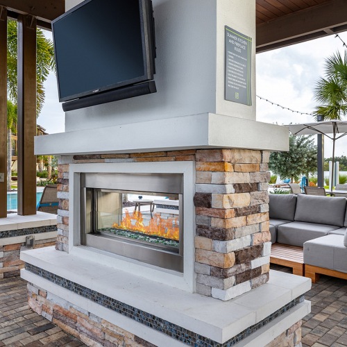 Resident patio with fireplace, TV and couch seating Resident patio with fireplace, TV and couch seating